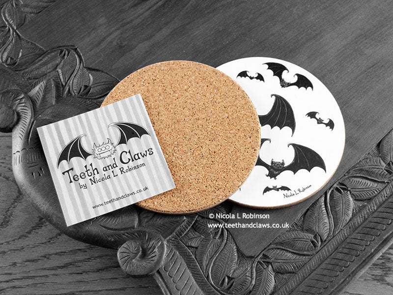 Gothic Bats Coaster featuring my original pen and ink illustration of gothic bats, back view showing the cork backing, alongside one of my branded cards. Made in the UK. Design and illustration © Nicola L Robinson | Teeth and Claws.