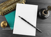 Black cat greeting card, shown open and flat with blank inside, on a teal envelope, alongside vintage Victorian pen and writing desk accessories. Design and illustration © Nicola L Robinson | Teeth and Claws