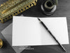 Blue Dragon greeting card, shown open and flat with blank inside, on a grey envelope, alongside vintage Victorian pen and writing desk accessories. Design and illustration © Nicola L Robinson | Teeth and Claws