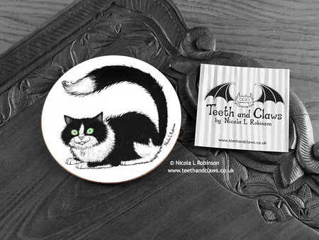 Black and White Cat Coaster featuring my original pen and ink illustration of a black and white cat, front view alongside one of my branded cards. Made in the UK. Design and illustration © Nicola L Robinson | Teeth and Claws.