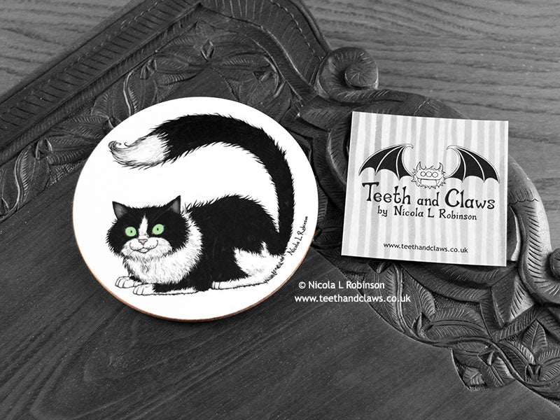 Black and White Cat Coaster featuring my original pen and ink illustration of a black and white cat, front view alongside one of my branded cards. Made in the UK. Design and illustration © Nicola L Robinson | Teeth and Claws.