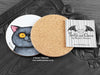 British Shorthair Cat Coaster, featuring my original pen and ink illustration of a grey British Shorthair cat, also back view showing the cork backing, alongside one of my branded cards. Made in the UK. Design and illustration © Nicola L Robinson | Teeth and Claws.
