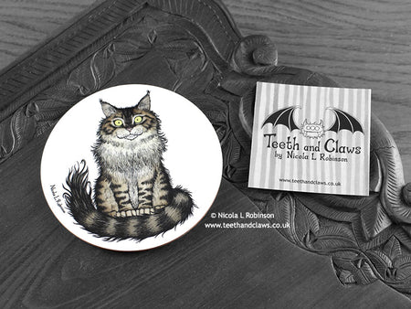 Maine Coon Cat Coaster featuring my original pen and ink illustration of a Maine Coon cat, front view alongside one of my branded cards. Made in the UK. Design and illustration © Nicola L Robinson | Teeth and Claws.