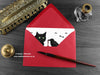 Black cat and crow love card, shown lying flat, with my original pen and ink illustration of a black cat and crow, inside an open red envelope. With vintage Victorian pen and writing desk accessories. Design and illustration © Nicola L Robinson | Teeth and Claws