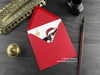 Black and White Cat Christmas card, shown lying flat, with my original pen and ink illustration of a festive cat, inside an open red envelope. With vintage Victorian pen and writing desk accessories. Design and illustration © Nicola L Robinson | Teeth and Claws
