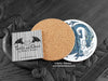 Blue Dragon Coaster featuring my original pen and ink illustration of a blue dragon, back view showing the cork backing, alongside one of my branded cards. Made in the UK. Design and illustration © Nicola L Robinson | Teeth and Claws.