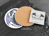 Purple Dragon Coaster featuring my original pen and ink illustration of a purple dragon, back view showing the cork backing, alongside one of my branded cards. Made in the UK. Design and illustration © Nicola L Robinson | Teeth and Claws.