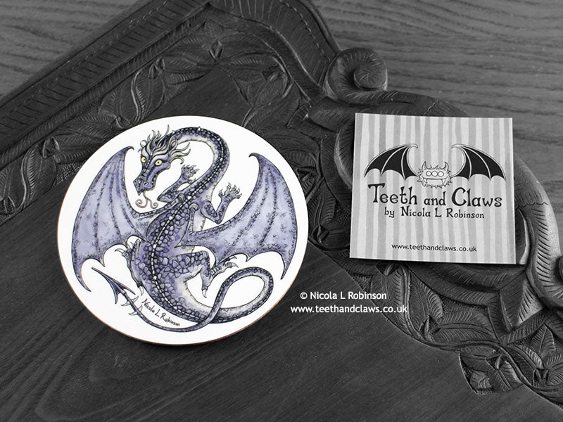 Purple Dragon Coaster featuring my original pen and ink illustration of a purple dragon, front view alongside one of my branded cards. Made in the UK. Design and illustration © Nicola L Robinson | Teeth and Claws.