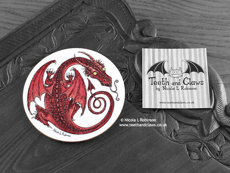 Red Dragon Coaster featuring my original pen and ink illustration of a red dragon, front view alongside one of my branded cards. Made in the UK. Design and illustration © Nicola L Robinson | Teeth and Claws.