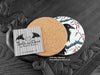 Crow Coaster featuring my original pen and ink illustration of a crow, back view showing the cork backing, alongside one of my branded cards. Made in the UK. Design and illustration © Nicola L Robinson | Teeth and Claws.