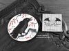 Crow Coaster featuring my original pen and ink illustration of a crow, front view alongside one of my branded cards. Made in the UK. Design and illustration © Nicola L Robinson | Teeth and Claws.