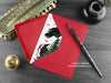 Crow Christmas card, shown lying flat, with my original pen and ink illustration of festive crows, inside an open red envelope. With vintage Victorian pen and writing desk accessories. Design and illustration © Nicola L Robinson | Teeth and Claws