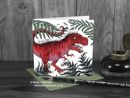 Trex and ferns greeting card, front view, featuring my original pen and ink dinosaur illustration. The card is standing on a green envelope, shown at an angle. Design and illustration © Nicola L Robinson | Teeth and Claws