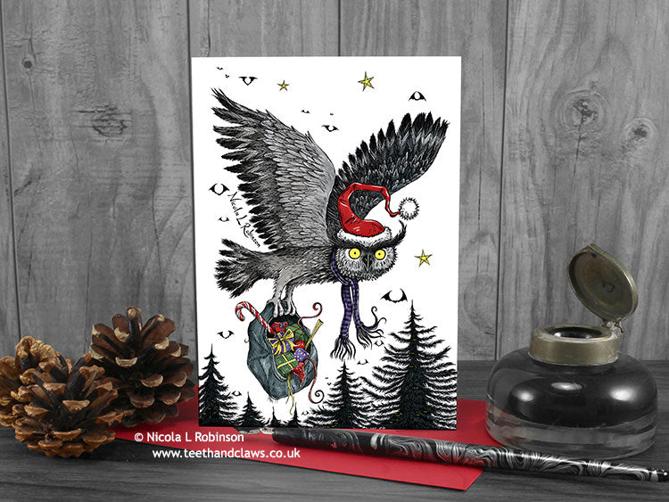 Flying Owl Christmas card, front view, featuring my original pen and ink owl illustration. The card is standing on a red envelope, shown at an angle. Design and illustration © Nicola L Robinson | Teeth and Claws