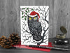 Gothic Owl Christmas card, front view, featuring my original pen and ink owl illustration. The card is standing on a red envelope, shown at an angle. Design and illustration © Nicola L Robinson | Teeth and Claws
