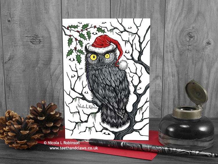 Gothic Owl Christmas card, front view, featuring my original pen and ink owl illustration. The card is standing on a red envelope, shown at an angle. Design and illustration © Nicola L Robinson | Teeth and Claws