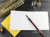 Bee Greeting card, shown open and flat with blank inside, on a yellow envelope, alongside vintage Victorian pen and writing desk accessories. Design and illustration © Nicola L Robinson | Teeth and Claws