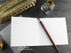 Dark Inky Dragon Greeting Card, shown open and flat with blank inside, on a grey envelope, alongside vintage Victorian pen and writing desk accessories. Design and illustration © Nicola L Robinson | Teeth and Claws