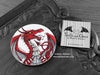 Red Dragon Coaster featuring my original pen and ink illustration of a red dragon, front view alongside one of my branded cards. Made in the UK. Design and illustration © Nicola L Robinson | Teeth and Claws.