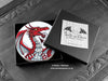 Set of four of my dragon coasters featuring my original pen and ink dragon illustrations, front view in an open black gift box with card. Made in the UK. Design and illustration © Nicola L Robinson | Teeth and Claws.