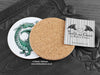 Green Dragon Coaster featuring my original pen and ink illustration of a green dragon, back view showing the cork backing, alongside one of my branded cards. Made in the UK. Design and illustration © Nicola L Robinson | Teeth and Claws.