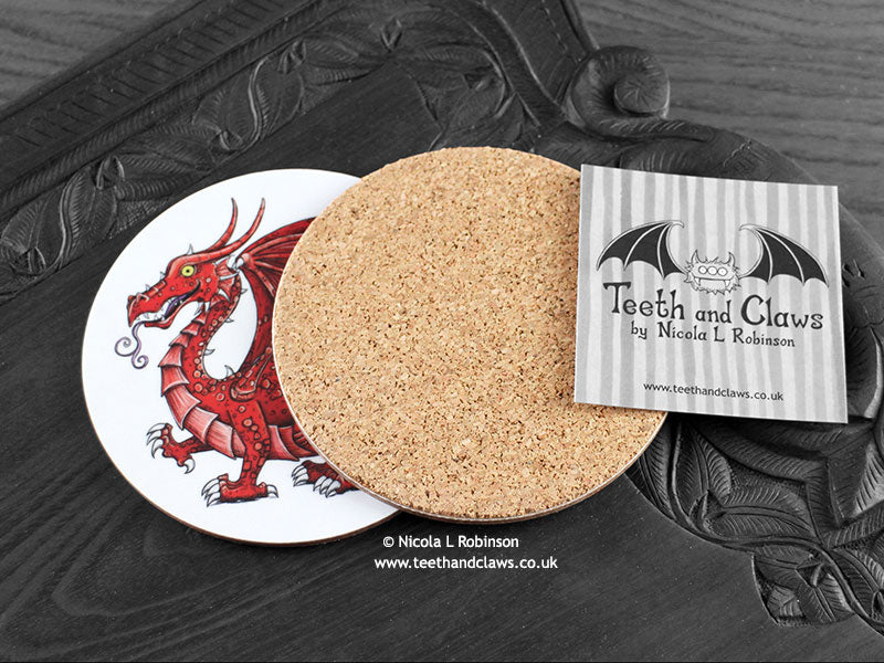 Welsh Dragon Coaster featuring my original pen and ink illustration of a Welsh dragon, back view showing the cork backing, alongside one of my branded cards. Made in the UK. Design and illustration © Nicola L Robinson | Teeth and Claws.