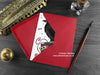 Raven Christmas card, shown lying flat, with my original pen and ink illustration of a festive raven, inside an open red envelope. With vintage Victorian pen and writing desk accessories. Design and illustration © Nicola L Robinson | Teeth and Claws