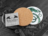 Green Dragon Coaster featuring my original pen and ink illustration of a green dragon, back view showing the cork backing, alongside one of my branded cards. Made in the UK. Design and illustration © Nicola L Robinson | Teeth and Claws.