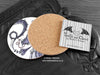 Purple Dragon Coaster featuring my original pen and ink illustration of a purple dragon, back view showing the cork backing, alongside one of my branded cards. Made in the UK. Design and illustration © Nicola L Robinson | Teeth and Claws.