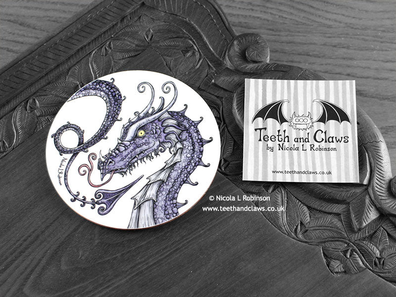 Purple Dragon Coaster featuring my original pen and ink illustration of a purple dragon, front view alongside one of my branded cards. Made in the UK. Design and illustration © Nicola L Robinson | Teeth and Claws.