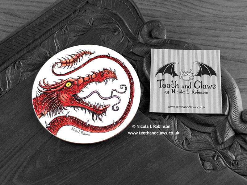 Red Dragon Coaster featuring my original pen and ink illustration of a red dragon, front view alongside one of my branded cards. Made in the UK. Design and illustration © Nicola L Robinson | Teeth and Claws.