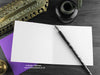 Gothic Spider Greeting card, shown open and flat with blank inside, on a purple envelope, alongside vintage Victorian pen and writing desk accessories. Design and illustration © Nicola L Robinson | Teeth and Claws