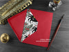 Spiders Christmas card, shown lying flat, with my original pen and ink illustration of festive spiders, inside an open red envelope. With vintage Victorian pen and writing desk accessories. Design and illustration © Nicola L Robinson | Teeth and Claws