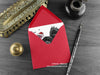 Gothic Turkey Christmas card, shown lying flat, with my original pen and ink illustration of a turkey, inside an open red envelope. With vintage Victorian pen and writing desk accessories. Design and illustration © Nicola L Robinson | Teeth and Claws