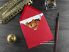 Cats Christmas card, shown lying flat, with my original pen and ink illustration of two festive cats, inside an open red envelope. With vintage Victorian pen and writing desk accessories. Design and illustration © Nicola L Robinson | Teeth and Claws