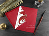 Dragon Christmas card, shown lying flat, with my original pen and ink illustration of a festive red dragon, inside an open red envelope. With vintage Victorian pen and writing desk accessories. Design and illustration © Nicola L Robinson | Teeth and Claws